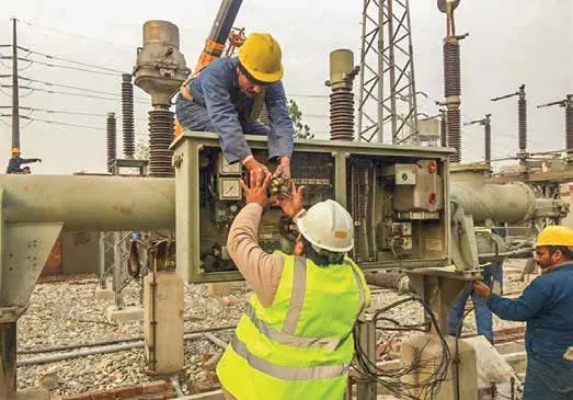 Technicians commissioning switchyard equipment